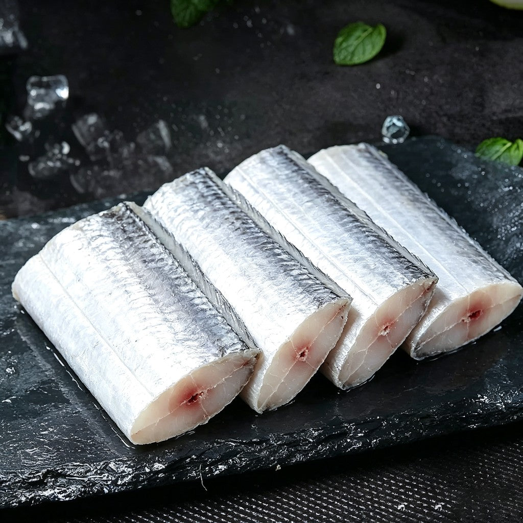 Raw beltfish middle-cut steaks arranged on a dark slate board
